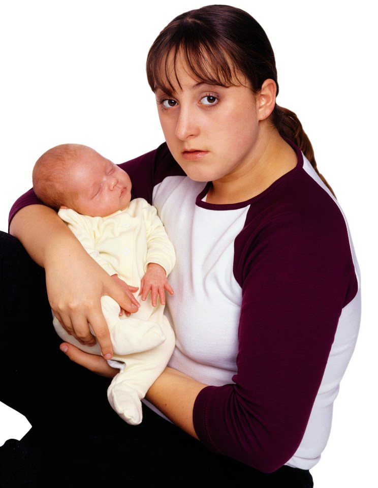 A woman holding a sleeping baby.