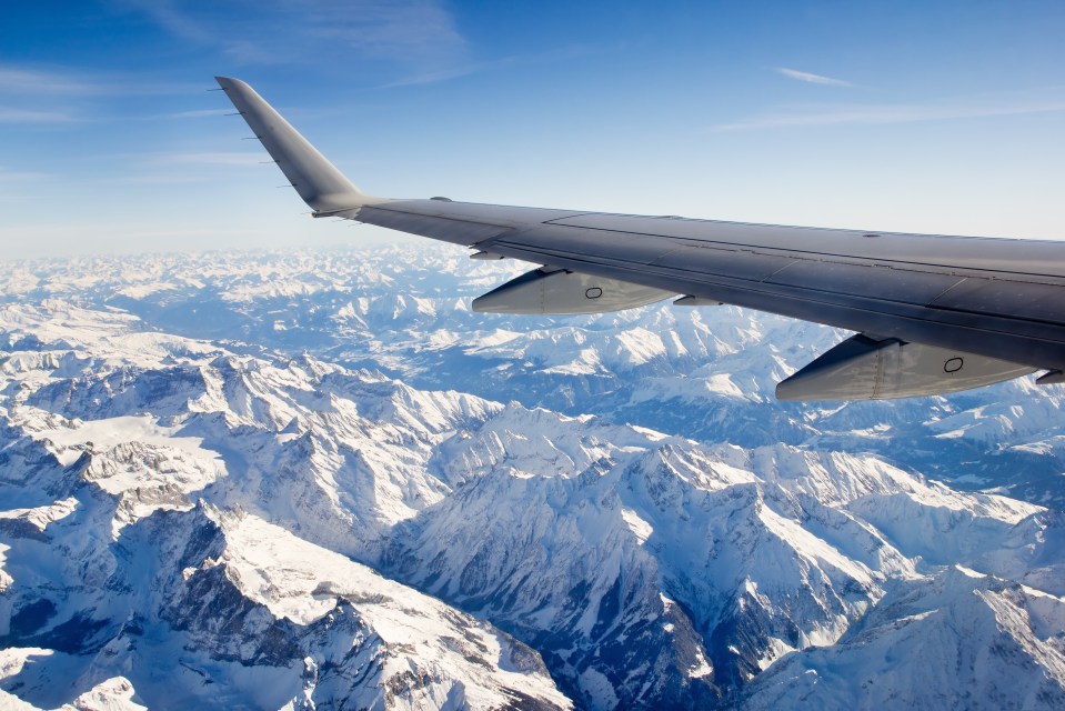 Aerial view of the snow-covered Alps from an airplane window.