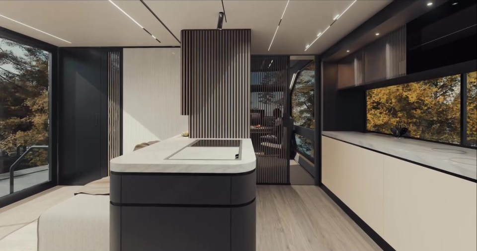 Interior view of a modern tiny home campervan kitchen and living area.