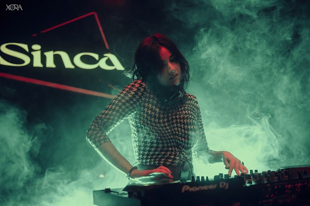 Sinca, a DJ, performing on stage.