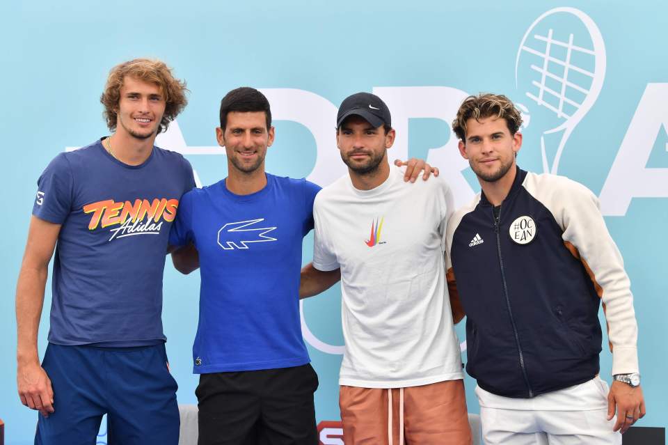 Four male tennis players posing together.