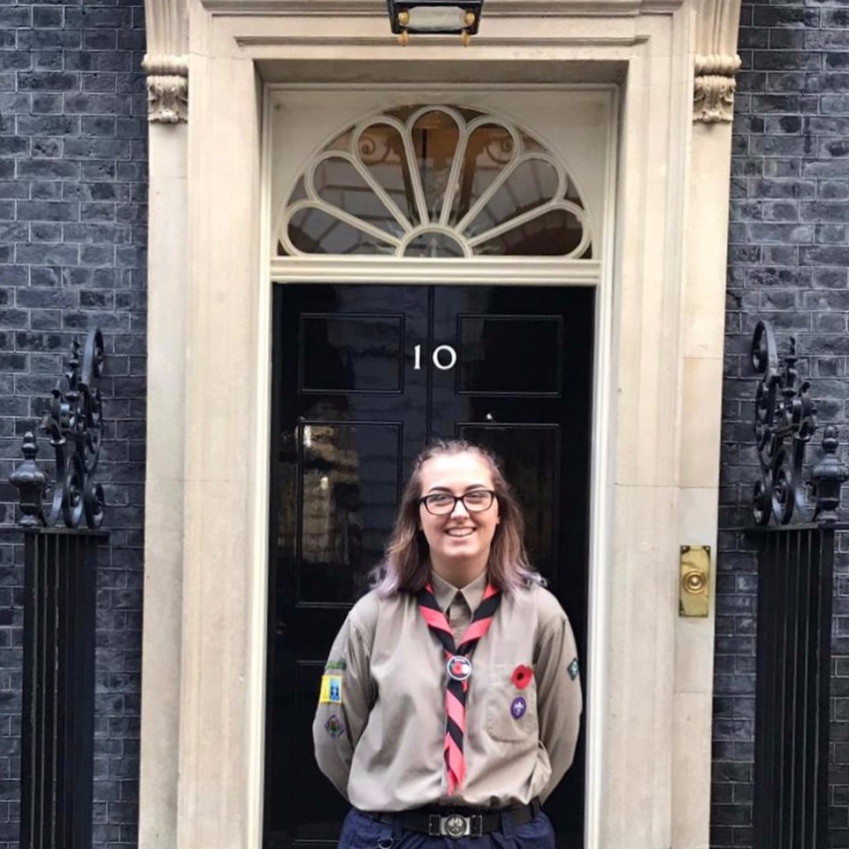 Girl Scout in uniform standing in front of 10 Downing Street.