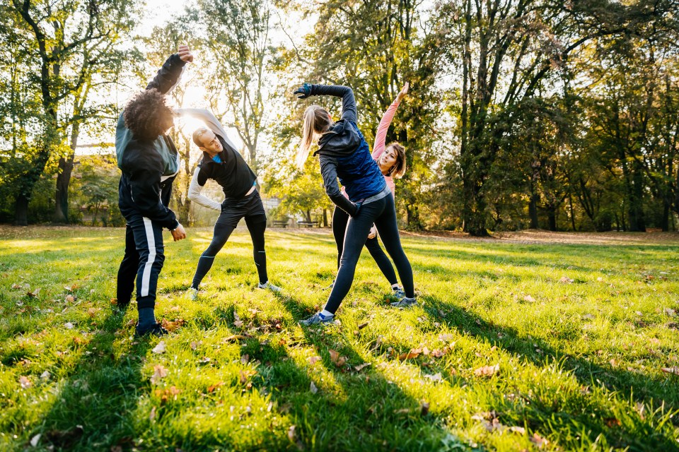 Athletes stretching in a park.