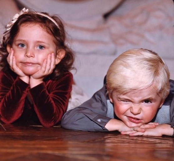 Young girl and boy siblings posing for a photo.