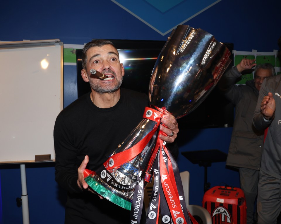 AC Milan's head coach celebrating with the Supercup trophy.