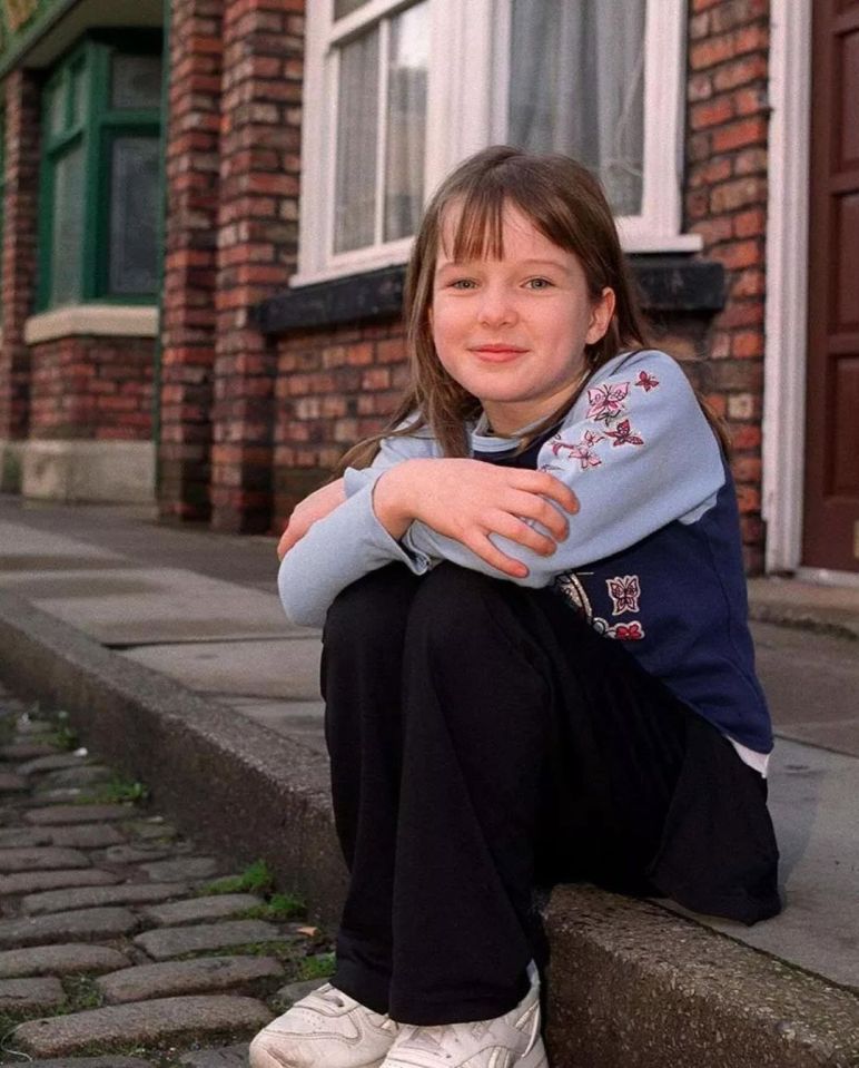 Young Helen Flanagan sitting on a curb.