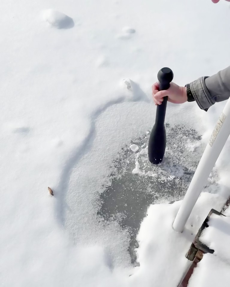 Person checking ice thickness with an ice pick.