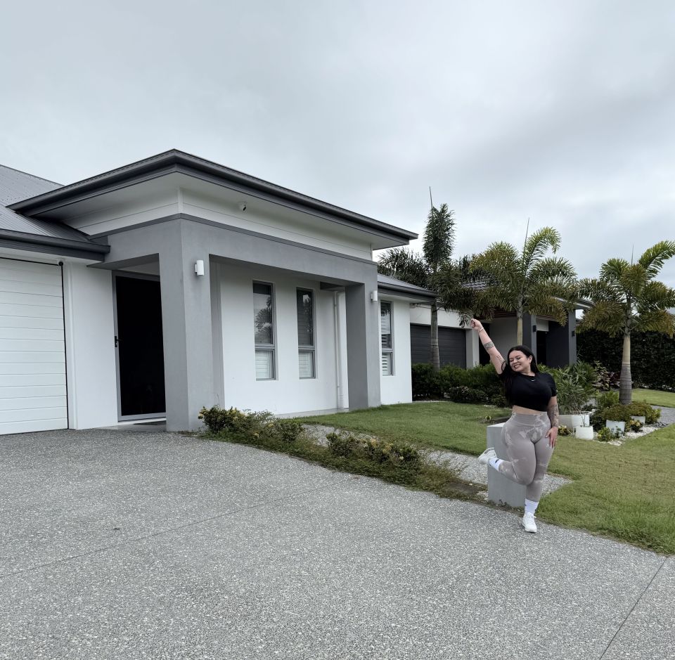 Woman standing in front of her new house.