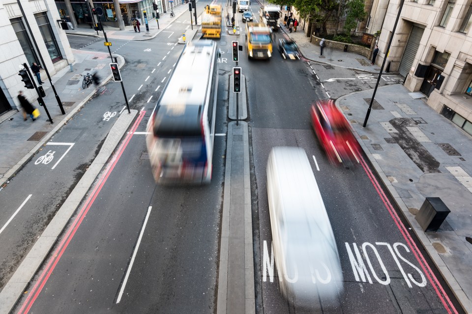 High-angle view of blurred vehicles on a busy city street.