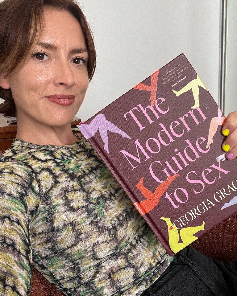 Woman holding "The Modern Guide to Sex" by Georgia Grace.