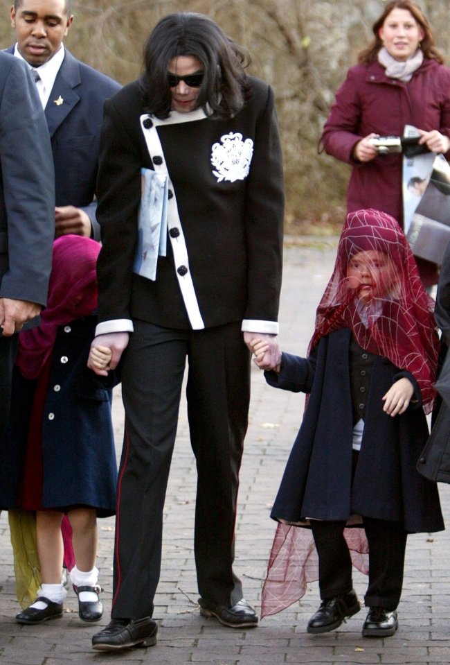 Michael Jackson holding hands with two children.