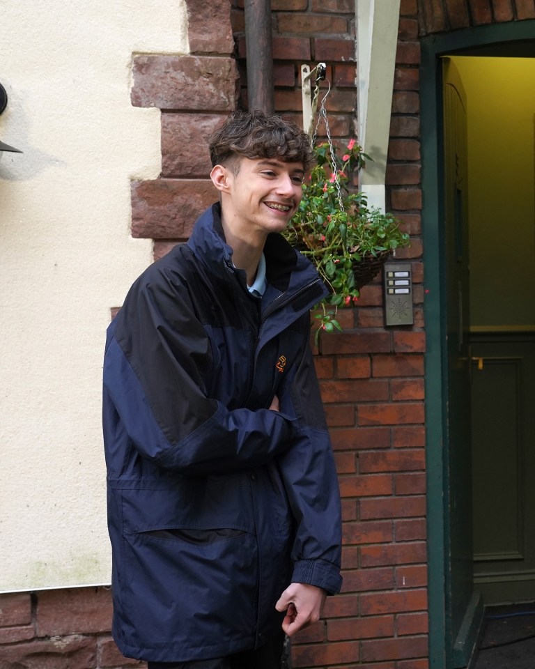 Smiling young man in a dark blue jacket.