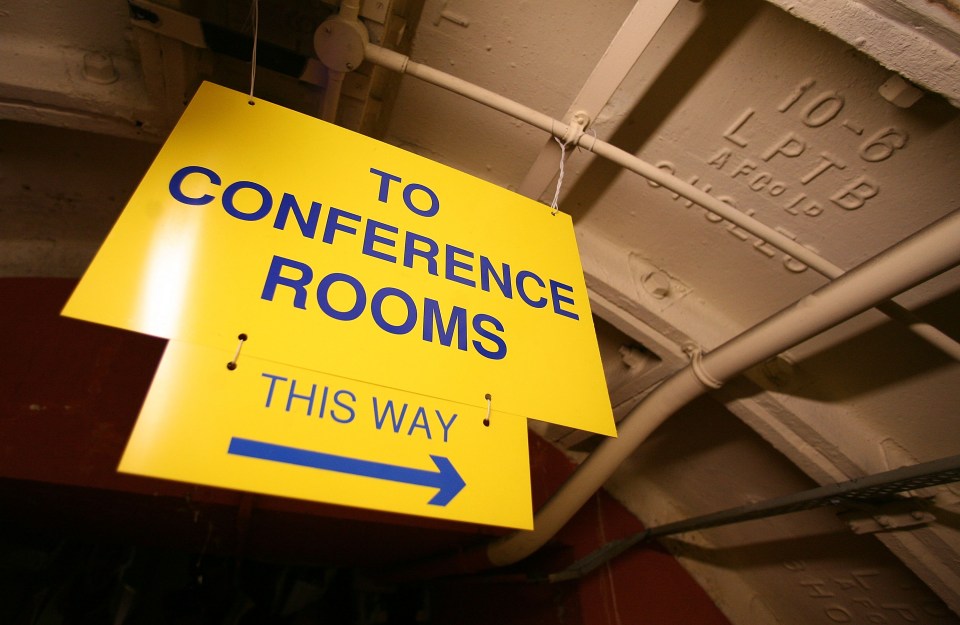 Yellow sign indicating the direction to conference rooms.