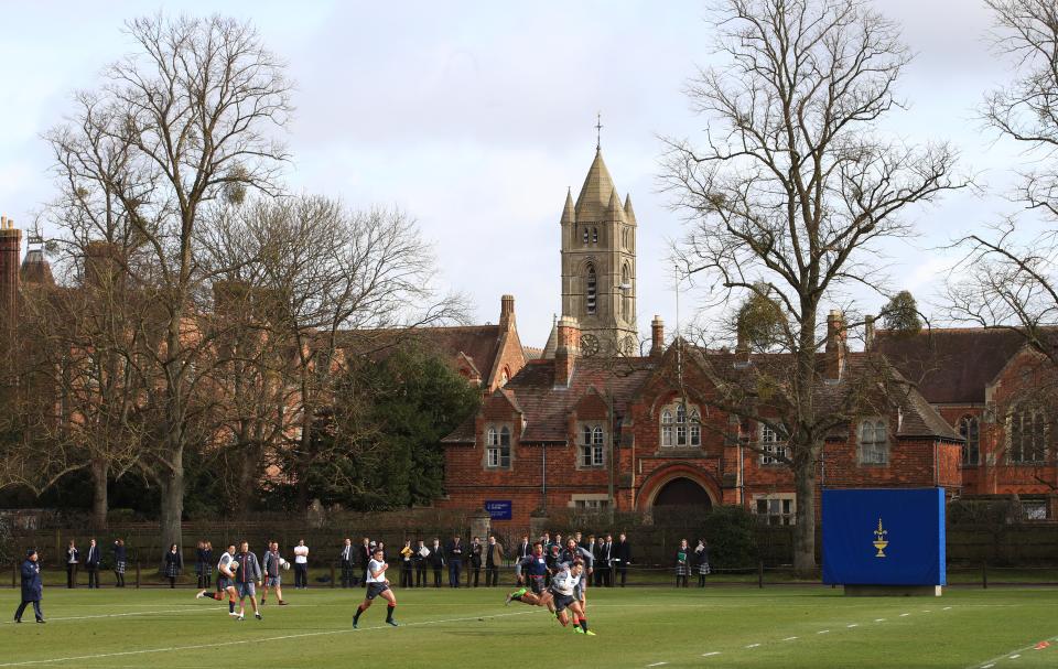 England rugby players training on a field in front of a school building.