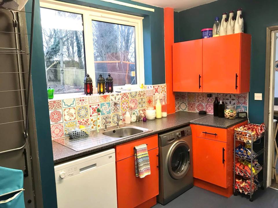 Orange kitchen makeover with patterned tile backsplash.