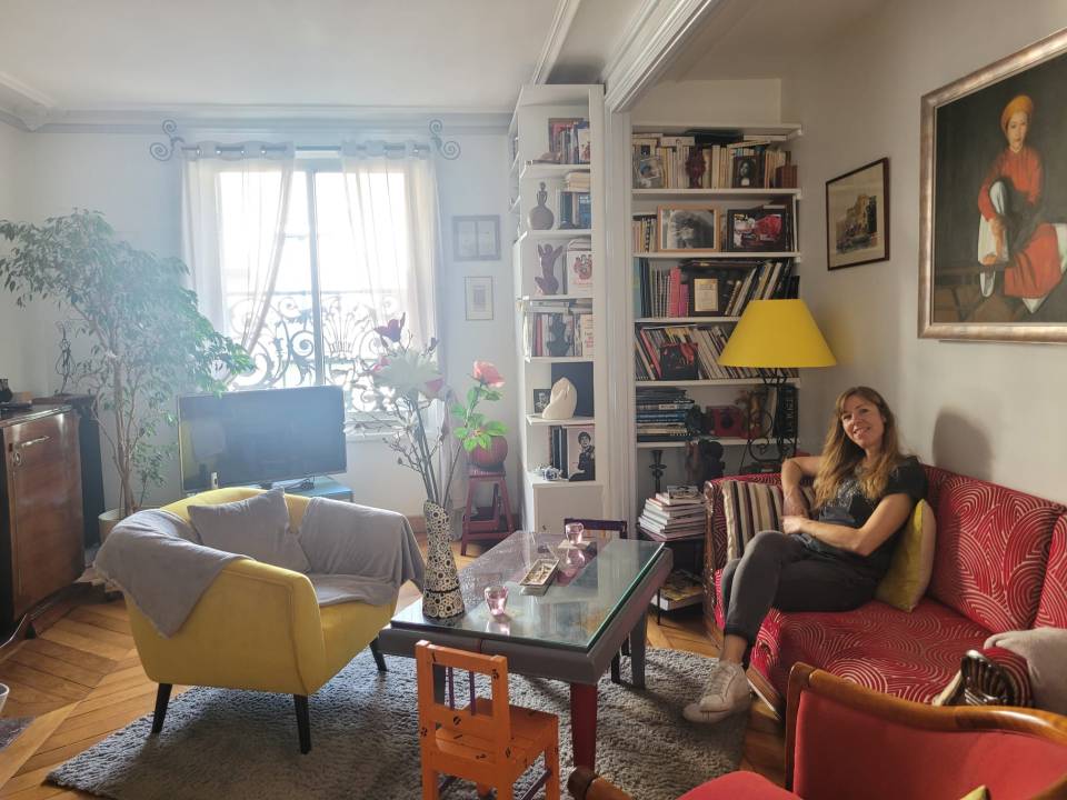 Woman sitting on a red couch in a living room.