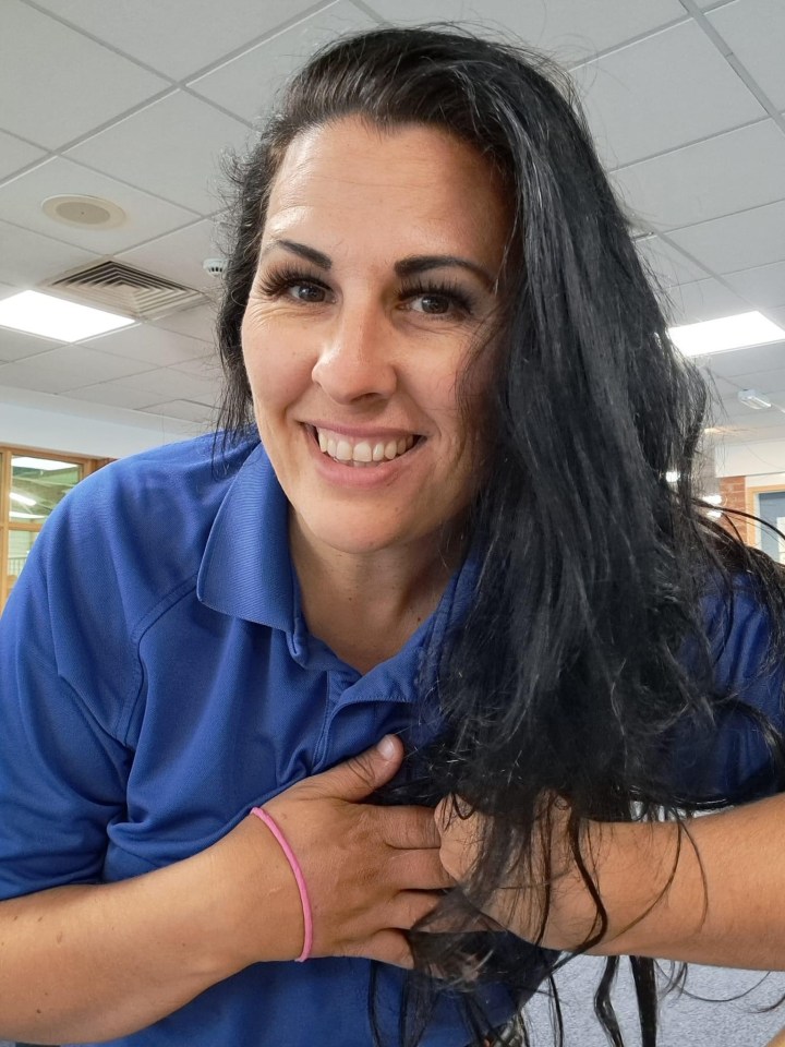 Woman with long dark hair smiling at the camera.