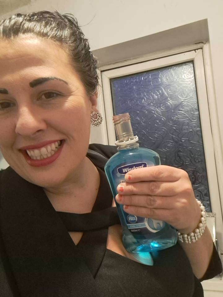 Woman holding a bottle of mouthwash.