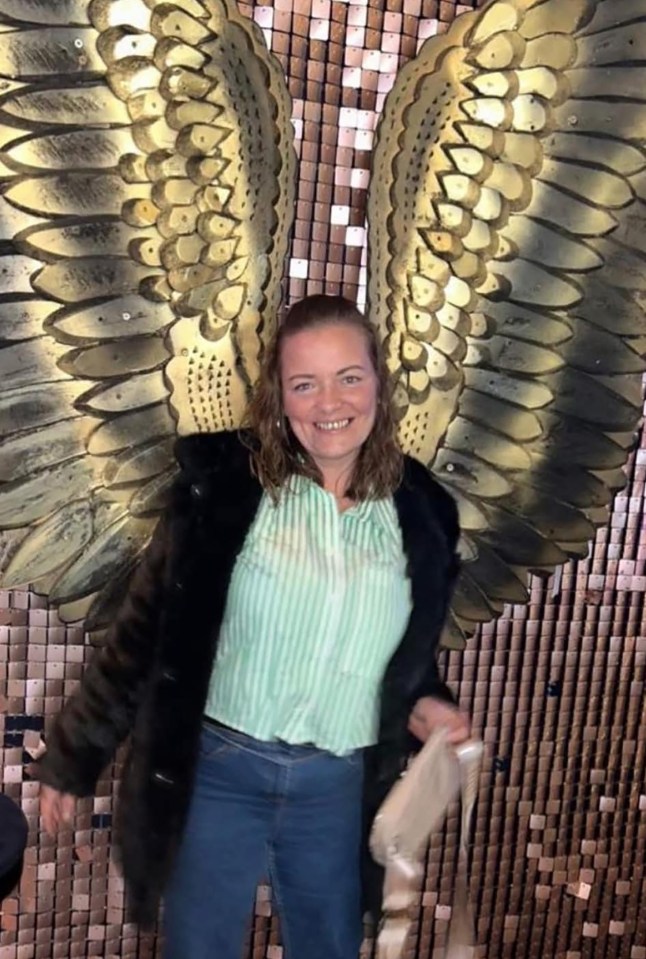 Woman standing in front of large angel wings.