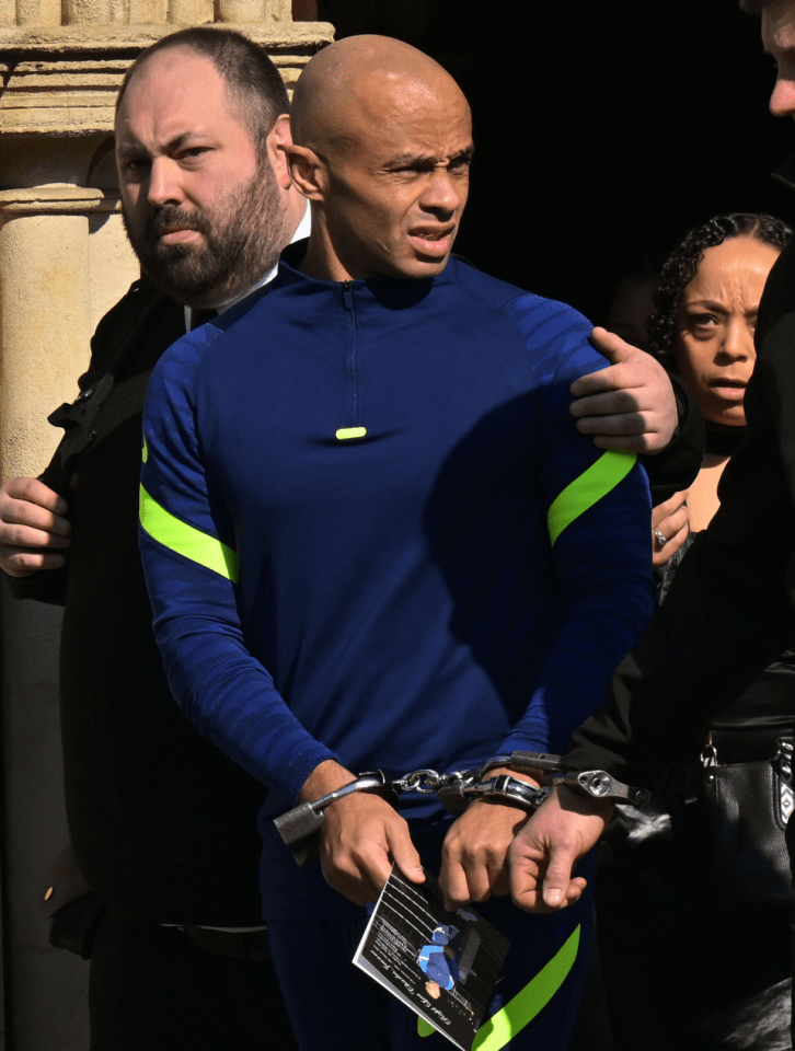 Man in handcuffs holding a card.