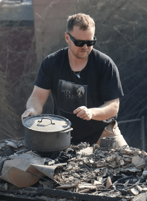 Man placing a pot on debris.