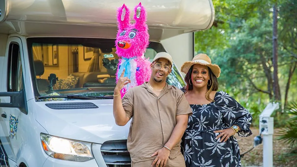 Couple standing in front of RV with piñata.