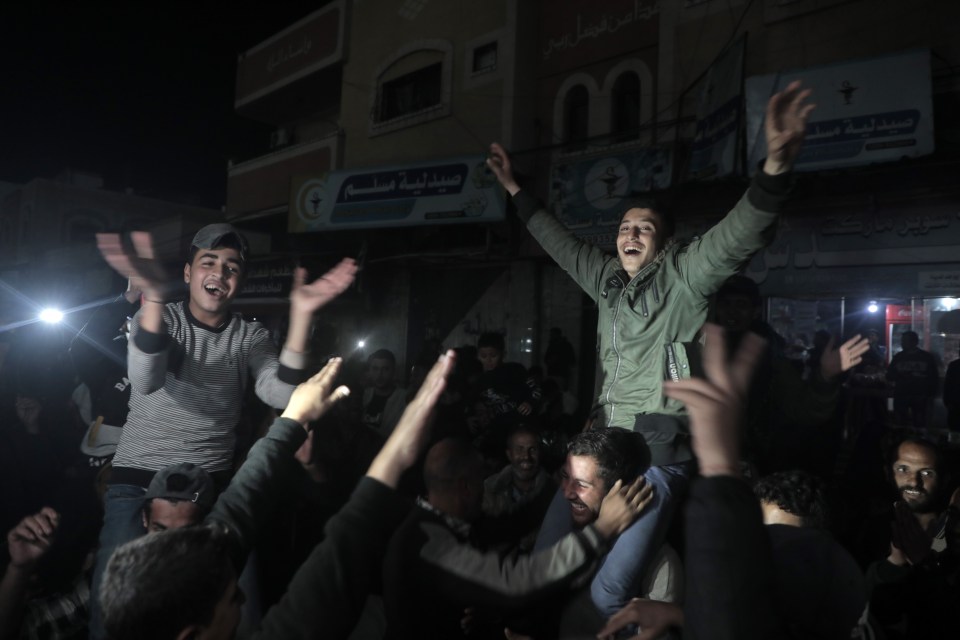 A young man is being carried on the shoulders of a crowd of people at night.