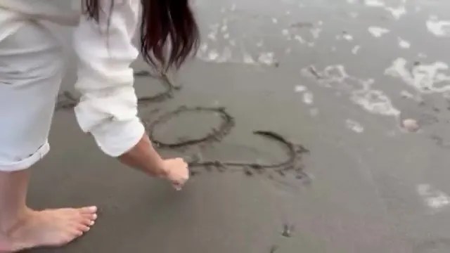 She then writes '2025' in the sand