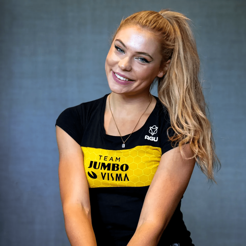 Woman smiling, wearing a Team Jumbo Visma shirt.