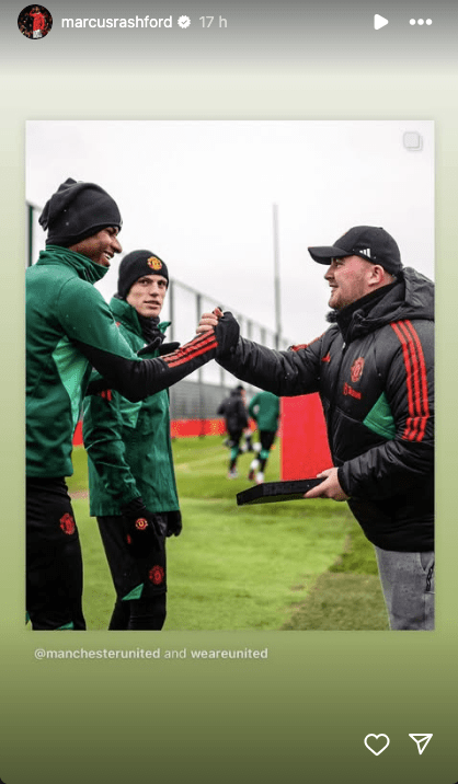 Manchester United players shaking hands with a coach.