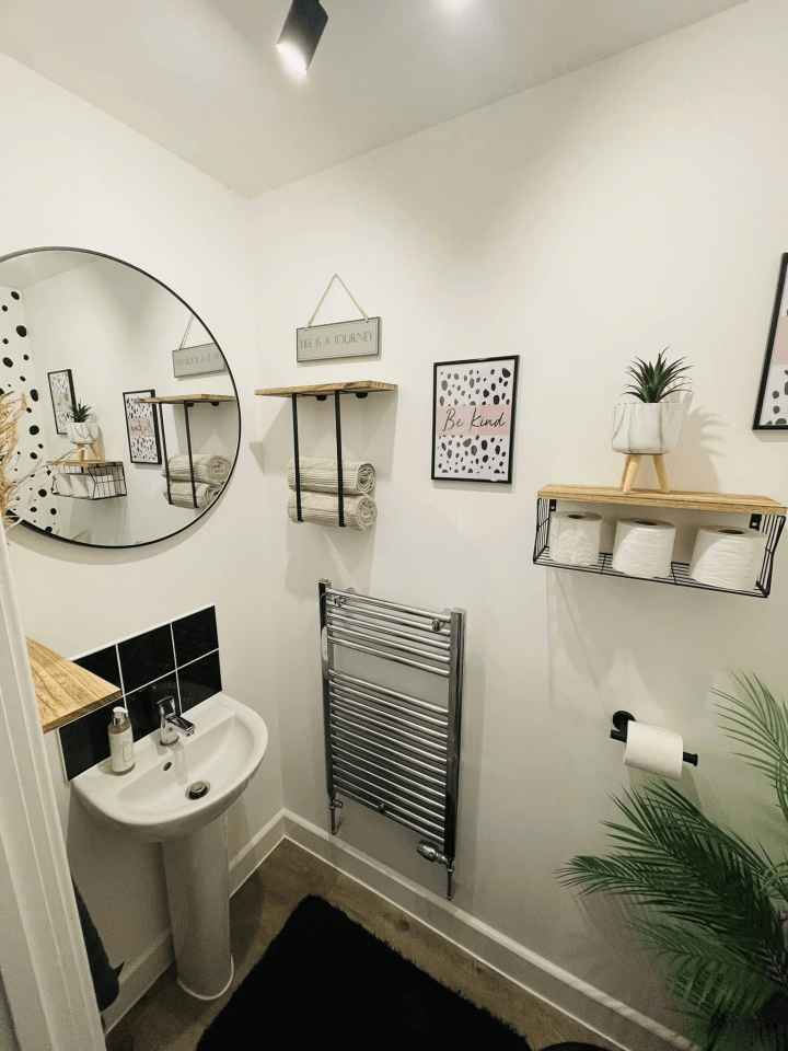 Small bathroom with sink, shelves, and decor.