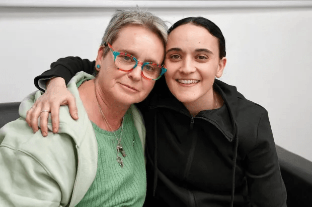 Two women posing for a photo, one with her arm around the other's shoulder.