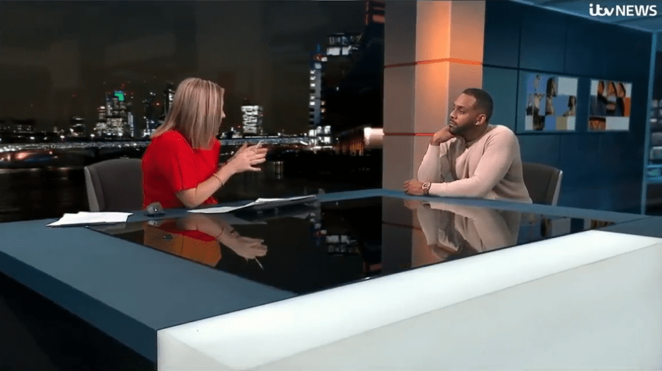 News interview with a woman in red and a man in beige.