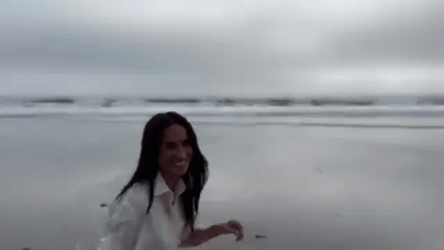 Meghan Markle smiling on a beach.