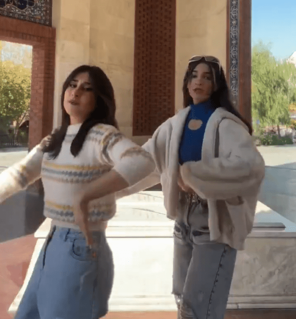 Two women dancing outdoors.