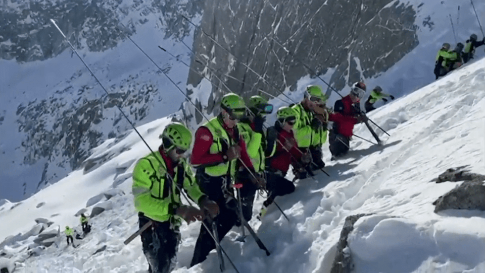 Mountain rescue team working on a snowy slope.