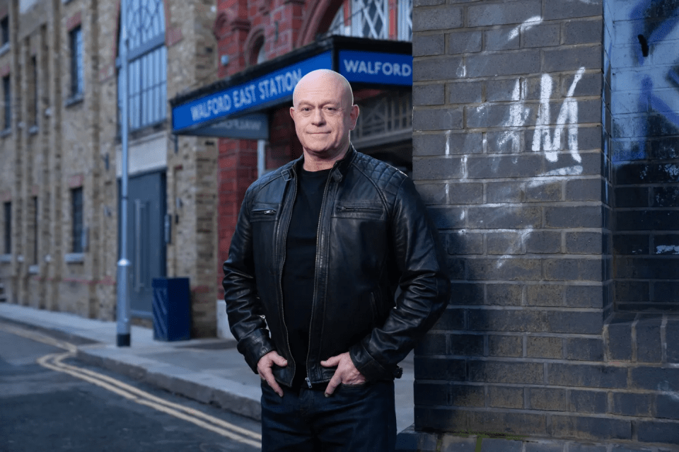 Man in black leather jacket standing near Walford East Station.