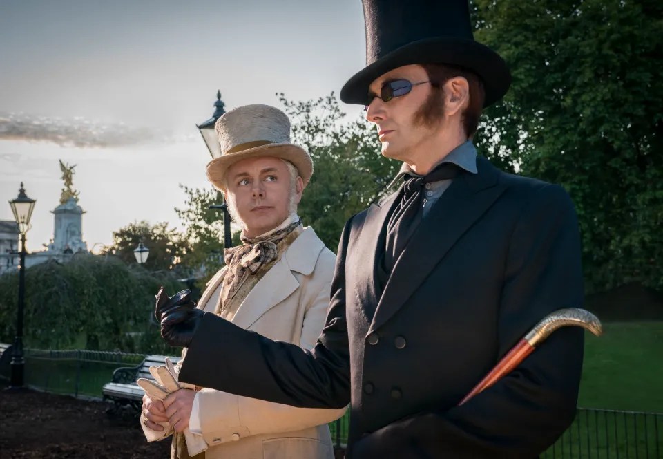 Two men in 19th-century attire stand outdoors.