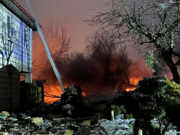 Firefighters battling a large fire near a building.