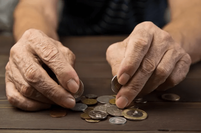 Elderly hands counting coins.