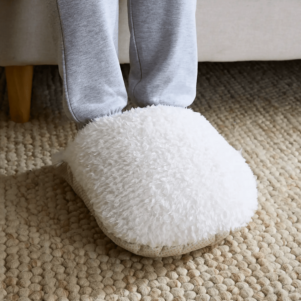 Person wearing fluffy white slippers.