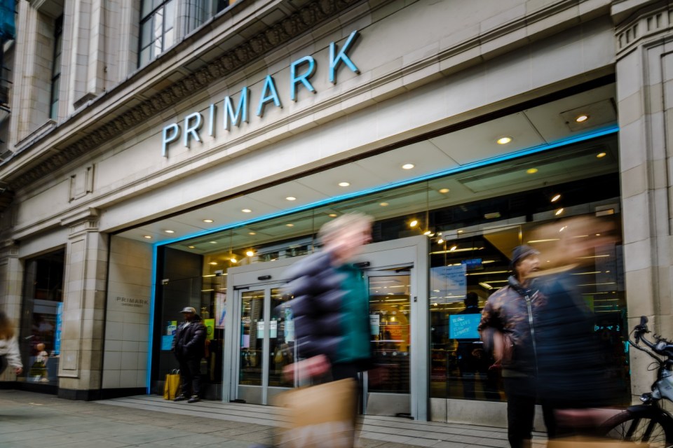 Exterior of a Primark store with blurred people walking by.