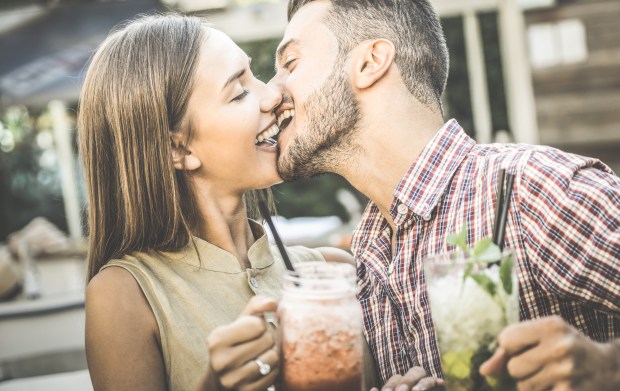 Couple kissing at a bar.