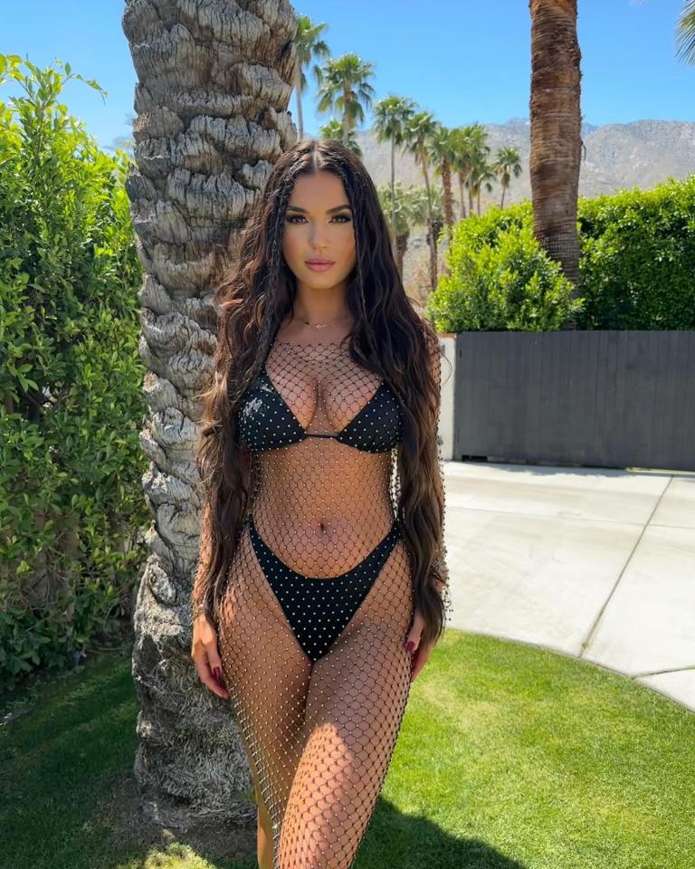 India Reynolds at Coachella wearing a black jeweled fishnet coverup over a bikini.