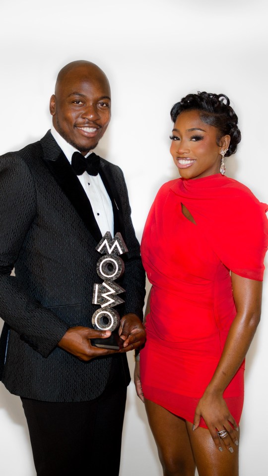 Eddie Kadi and Indiyah Polack, hosts of the MOBO Awards, holding an award.