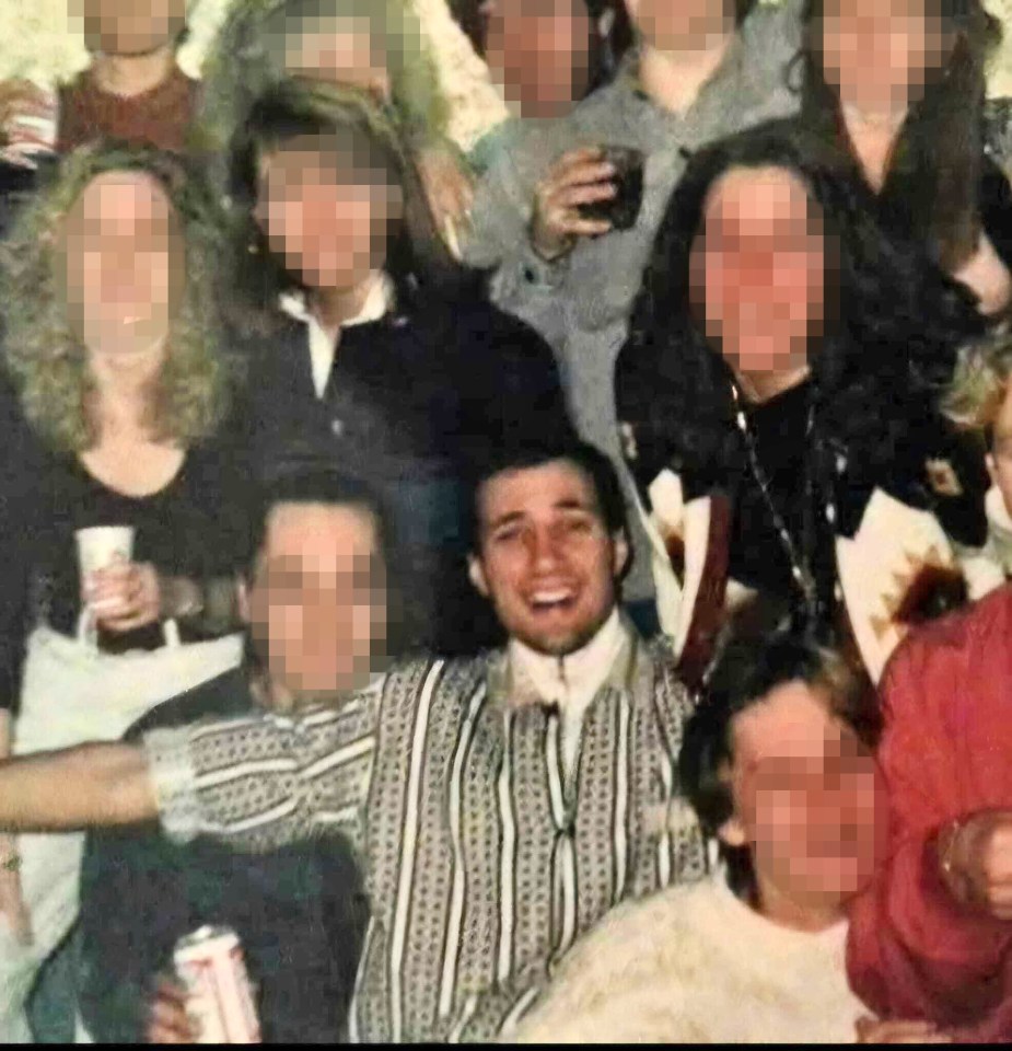 Photo of a man among a group of people, faces blurred for privacy.