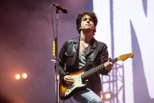 Elijah Hewson of Inhaler performing on stage with a guitar.