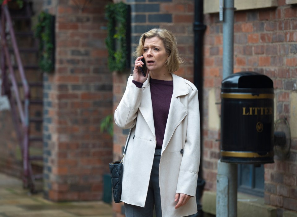 A woman on a cell phone, looking distressed.