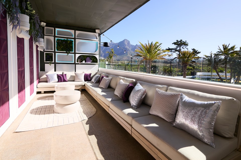 Love Island All Stars villa patio with seating area and mountain view.