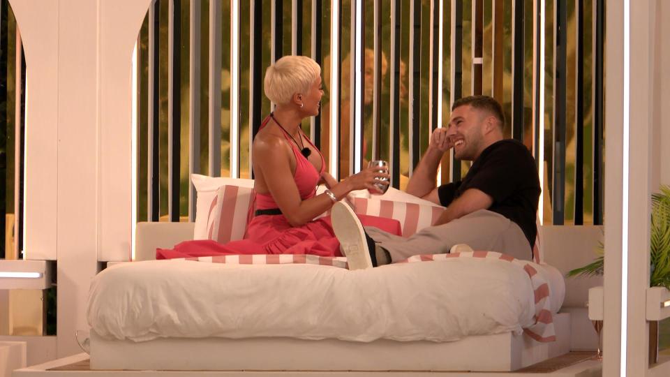 Kaz and Curtis from Love Island All Stars sitting on a bed and talking